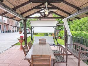 a wooden pergola with a table and chairs at Holiday Home Il Cavaliere by Interhome in Castellero