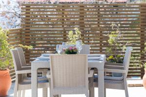 a table with chairs and wine glasses on a patio at Villa Eftychia - Panoramic Sea View in Svoronata +34 photos