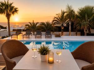 a table with two glasses of wine on top of a pool at Villa Claus - Private Pool Oasis in Puerto Calero in Puerto Calero +10 photos