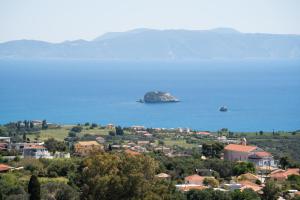 a small island in the water next to a town at Villa Eftychia - Panoramic Sea View in Svoronata
