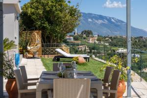 a patio with a table and chairs with a view at Villa Eftychia - Panoramic Sea View in Svoronata
