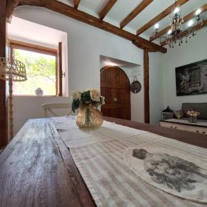 a vase with flowers on a table in a room at Casa di Sofiana by wood and stone in Áyios Pétros
