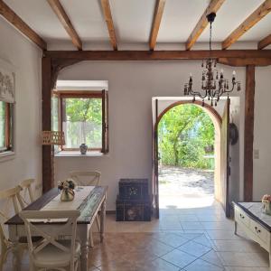 a dining room with a table and an open door at Casa di Sofiana by wood and stone in Áyios Pétros