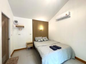 a small bedroom with a bed in a room at ลิตเติ้ล แคมป์ ชะอม in Ban Bung Mai