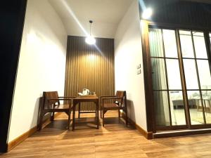 a dining room with a table and chairs and a window at ลิตเติ้ล แคมป์ ชะอม in Ban Bung Mai