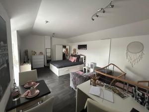 a living room with a bed and a dining room at La Vie est Belle chambre d hôte in Verviers