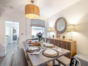 a dining room with a table and a mirror at Big Skies in Lowestoft