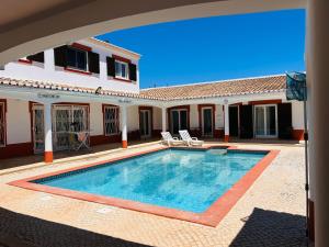a swimming pool in front of a house at Villa Madeira in Silves