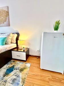 a living room with a bed and a white refrigerator at Casa Cristian Techirghiol in Techirghiol