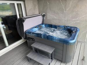 a jacuzzi tub with a bench next to a window at Beech Hill Hotel & Spa in Windermere
