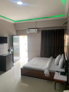 a bedroom with a bed with a green ceiling at Torax Lodge in Ibadan