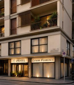 a facade of a hotel with windows and plants at Hotel Luxor Florence in Florence