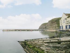 a building on the shore of a body of water at Bosuns Rest - 16265 in Staithes