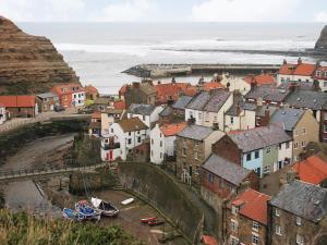 a town on the coast with the ocean in the background at Bosuns Rest - 16265 in Staithes
