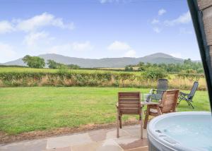 a patio with two chairs and a table and a tub at South View Retreat in Carlton