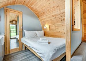 a bed in a tiny house with a wooden ceiling at South View Retreat in Carlton