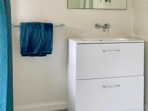 a bathroom with a white sink and a blue towel at Tigh An Dun in Luib +9 photos