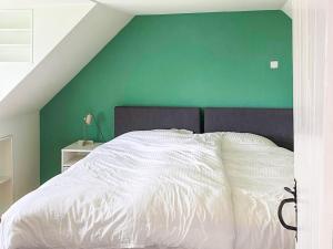 a bedroom with a green wall and a white bed at Tigh An Dun in Luib