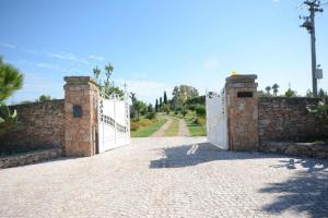 a stone fence with a white gate and a driveway at Tenuta Espada Gallipoli in Gallipoli