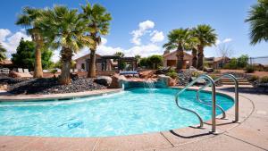 a swimming pool with a waterfall and palm trees at Adventure Awaits #81 townhouse in Santa Clara