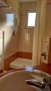 Aparthotel Lekavski في زاتون: حمام مع حوض ودش وحوض استحمام