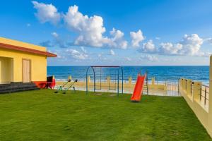 a playground on the beach with the ocean in the background at Aryans Sea Sight Resort Mandarmani in Mandarmoni