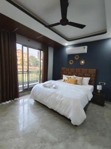 a bedroom with a large bed with a ceiling fan at 12 Summits Elite Stays in Dehradun