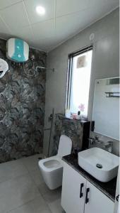 a bathroom with a toilet and a sink at 12 Summits Elite Stays in Dehradun +5 photos