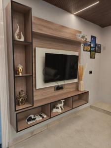 a living room with a television on a wall at 12 Summits Elite Stays in Dehradun