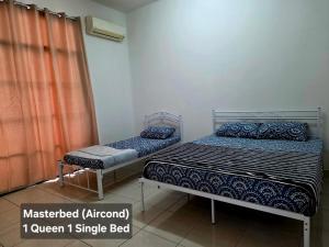 two beds in a small room withermottermottermott at Osvy Palm Homestay in Penampang