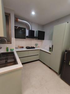 a kitchen with white cabinets and a refrigerator at 12 Summits Elite Stays in Dehradun