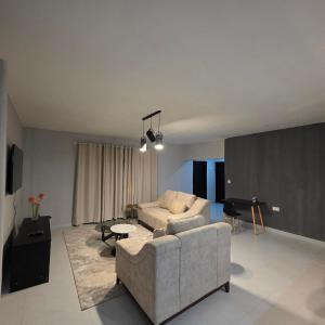 a living room with a couch and a piano at Fully Furnished Apartments in Manyama, Lumwana Mine in Chanamo