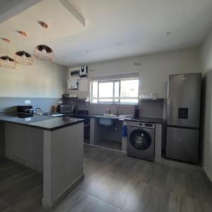 a kitchen with a washing machine and a washer at Fully Furnished Apartments in Manyama, Lumwana Mine in Chanamo