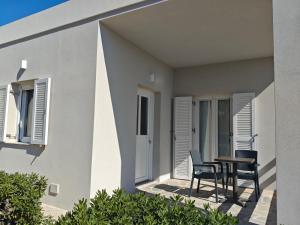 a house with two chairs and a table on a porch at Tramonto Nel Delfini in Kini