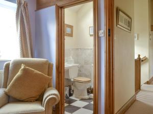 a bathroom with a chair and a toilet at Cass Lodge in Huby
