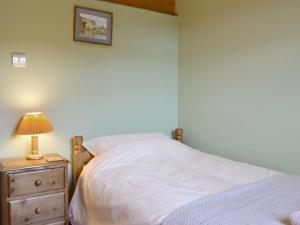 a bedroom with a bed and a lamp on a night stand at Cass Lodge in Huby