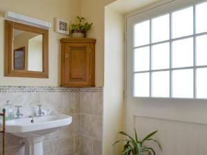 a bathroom with a sink and a mirror and a window at Cass Lodge in Huby
