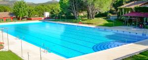 a large swimming pool with blue water at Camping El Canto la Gallina in Valdemaqueda