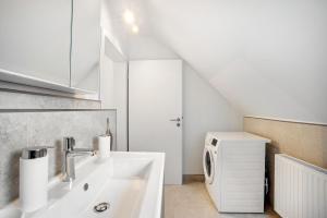 a white bathroom with a sink and a microwave at Ferienwohnung Nordic Stay Bäk in Bäk +19 photos