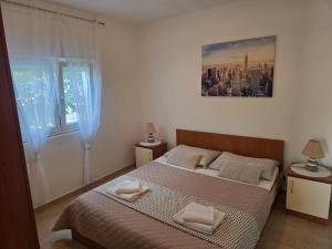 a bedroom with a bed with two towels on it at Apartments Bralic in Bibinje