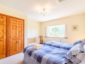 a bedroom with two beds and a window at Town Head Cottage in Carlton