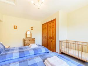 a bedroom with a bed and a crib at Town Head Cottage in Carlton