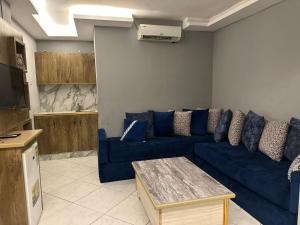a living room with a blue couch and a table at فندق كلاسيك in Aqaba