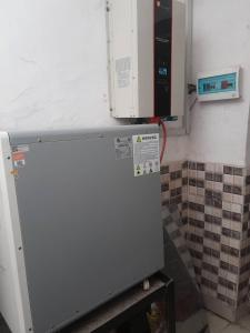 a refrigerator in a kitchen with a microwave above it at St Nicholas Guest Inn in Galadima