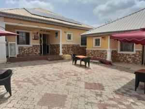a patio with a table and chairs in front of a building at St Nicholas Guest Inn in Galadima