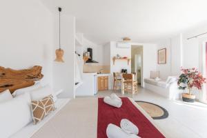 a white living room with a red rug on the floor at Casa Philippi Suites in Mikonos