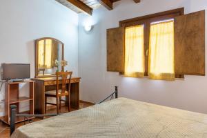 a bedroom with a bed and a desk with a mirror at Lemalu con giardino in Menfi