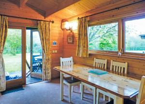 a dining room with a wooden table and chairs at Goodiford Mill Lakes in Kentisbeare