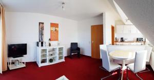 a living room with a table and a tv in a room at Urlaubslust Ferienhaus 12 in Trassenheide +35 photos