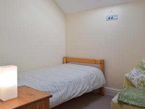 a small bedroom with a bed and a table at Goslings in Marloes